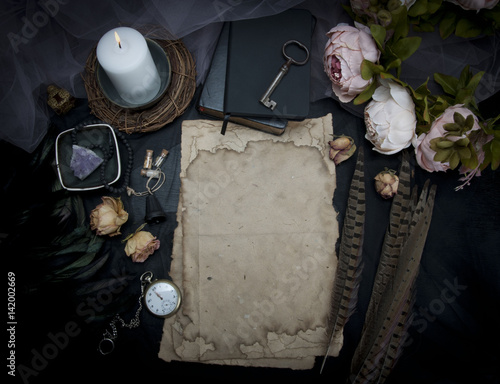 Vintage table with paper, flowers, old watch and candle