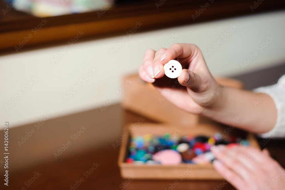 white sewing button in hand white sewing button in hand