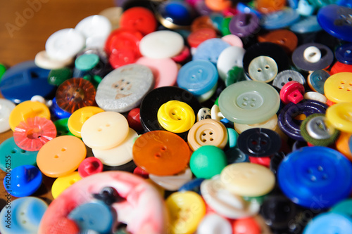 Lot of colorful plastic clothing buttons. Many small round vintage buttons pattern background