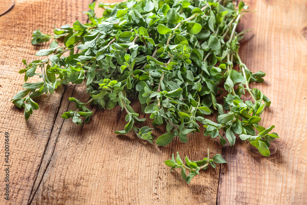 Spicy herb marjoram on a wooden table Spicy herb marjoram on a wooden table
