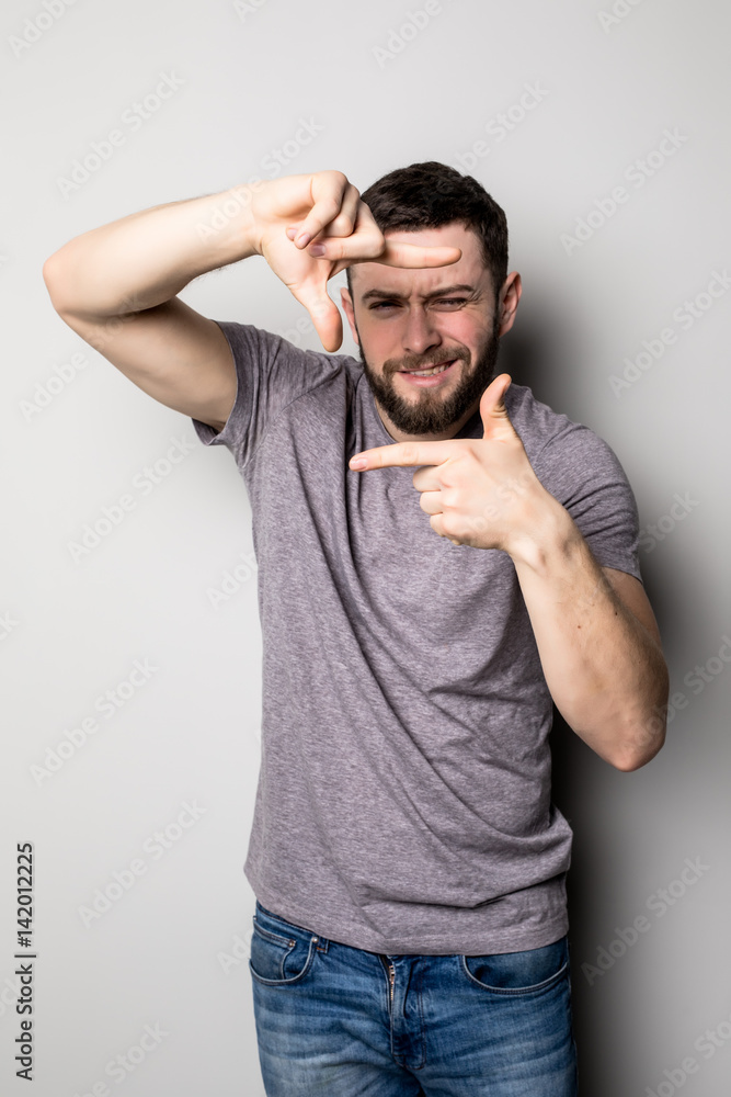 Man framing photograph over gray background Man framing photograph over gray background
