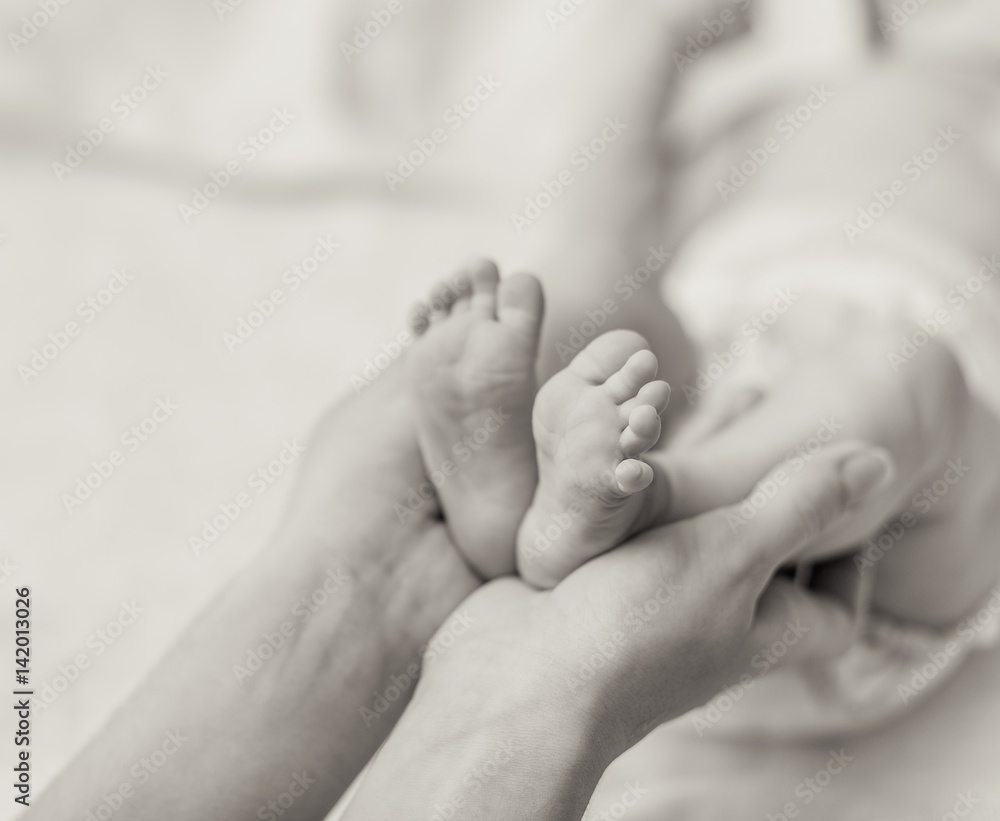 Mother holding tiny foot of newborn baby Mother holding tiny foot of newborn baby