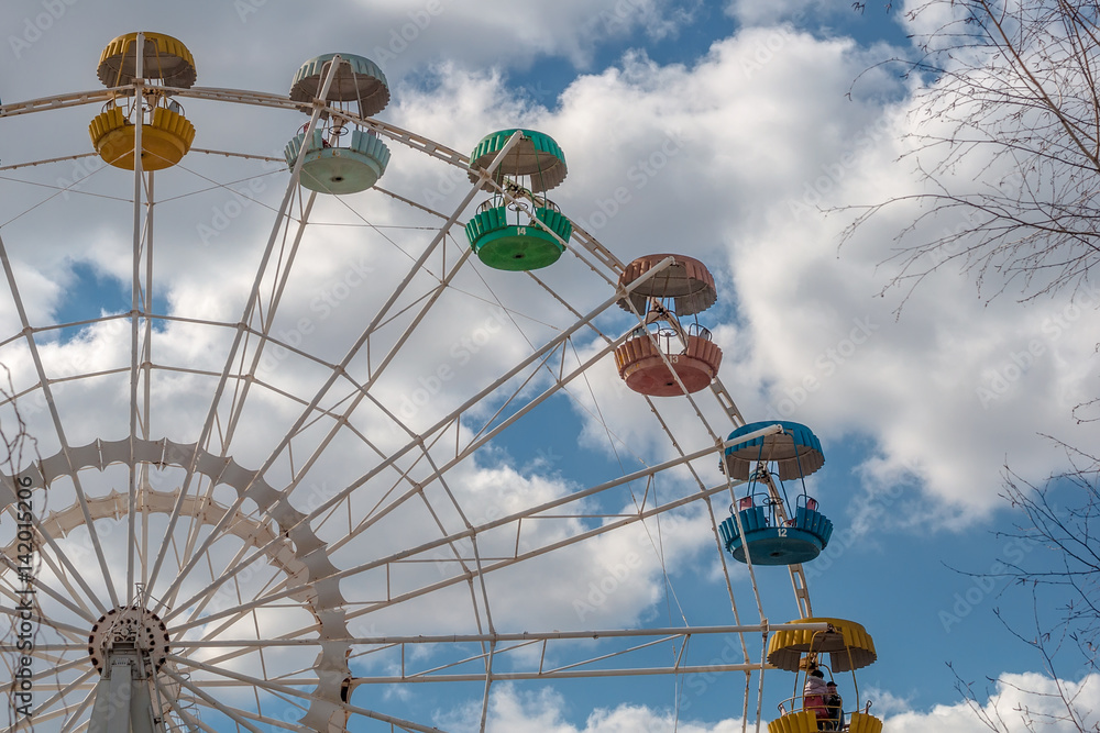 La ruota panoramica e il cielo azzurro con le nuvole bianche La ruota panoramica e il cielo azzurro con le nuvole bianche