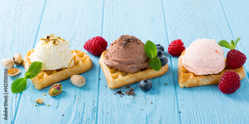 Homemade chocolate, raspberry and vanillaice cream on heart waffle on blue wooden background. Healthy summer food concept. photo