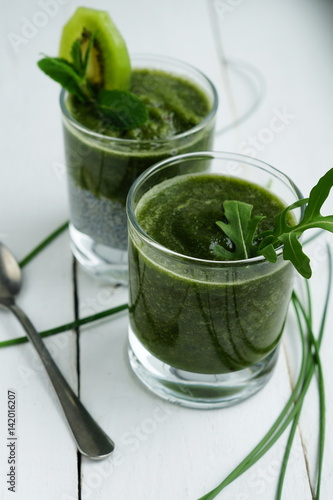 a healthy chia pudding with green smoothies on a light background