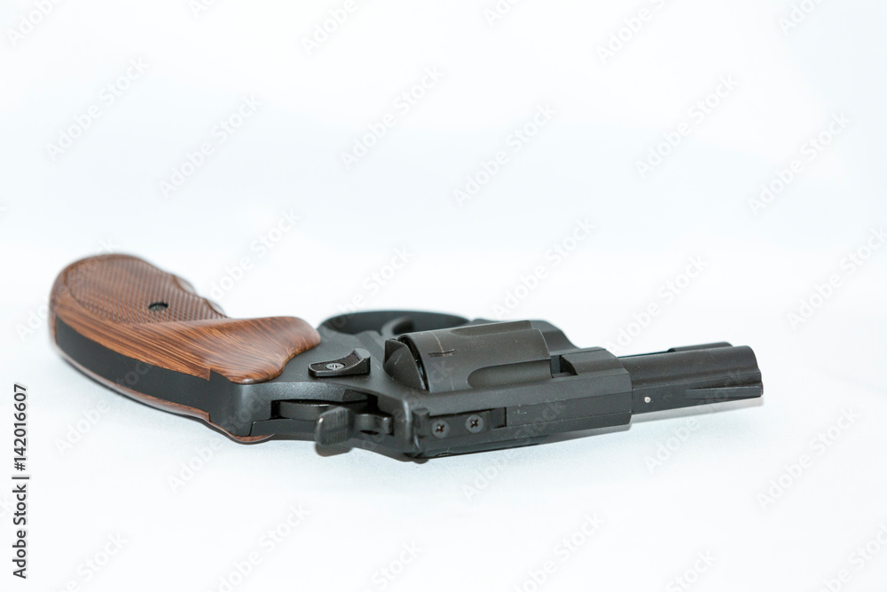 Small black handgun with a wooden handle on a white background Small black handgun with a wooden handle on a white background