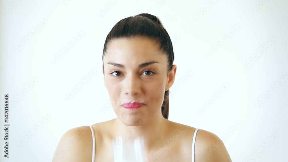 Close up portrait of cheerful brunette woman drinking glass of milk and having milk mustache, on isolated white background Close up portrait of cheerful brunette woman drinking glass of milk and having milk mustache, on isolated white background