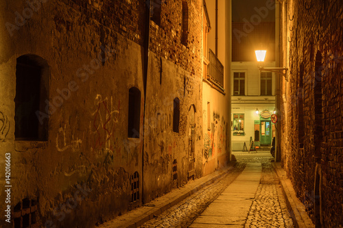 Narrow street in old town of Torun at night. Poland. Europe.