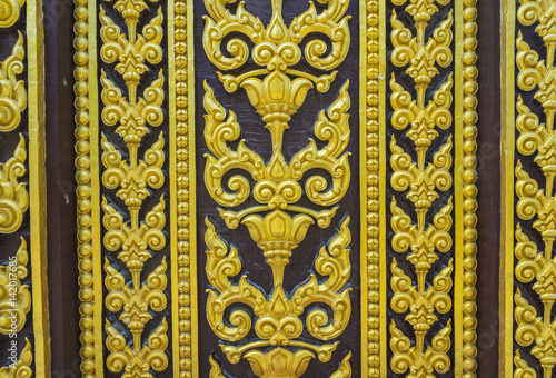Temple door decorated with gold leaf designs Thailand