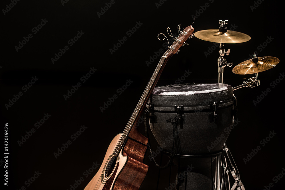 percussion instruments with an acoustic guitar on wooden boards with a black background