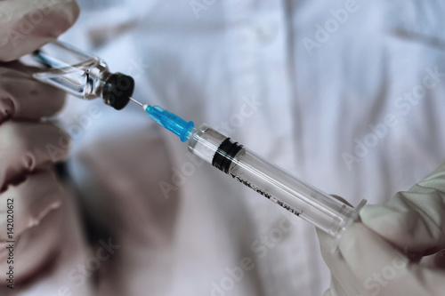 health worker dials the vaccine into a syringe