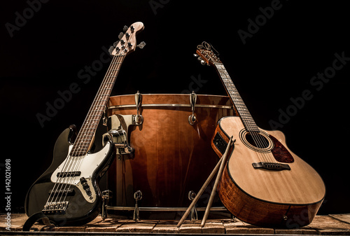 musical instruments, bass drum barrel acoustic guitar and bass guitar on a black background