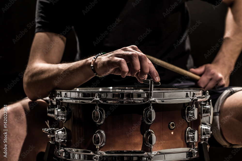 man adjusts a percussion instrument, musical concept with the working drum man adjusts a percussion instrument, musical concept with the working drum