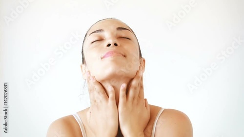 Portrait of beautiful brunette woman applying cream on her face