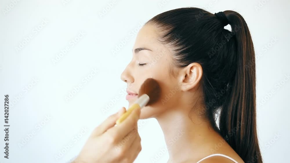 Man hand applying blush on female face Man hand applying blush on female face