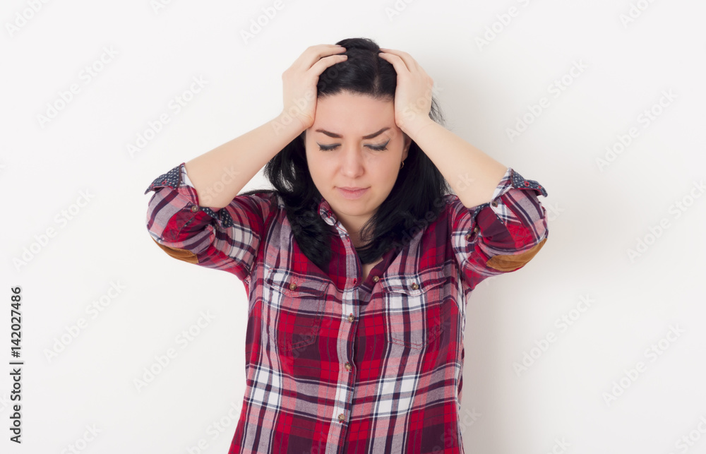 Beautiful suffering girl has a headache, high blood pressure or migraine, she holds her head, isolated on white background Beautiful suffering girl has a headache, high blood pressure or migraine, she holds her head, isolated on white background