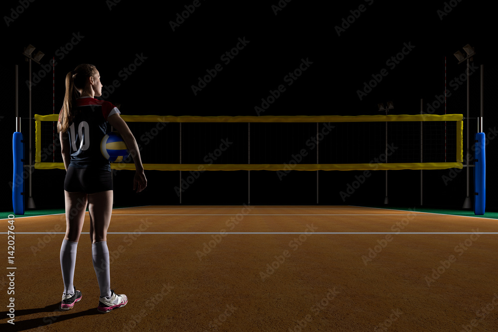 Female volleyball player standing with the volley ball
