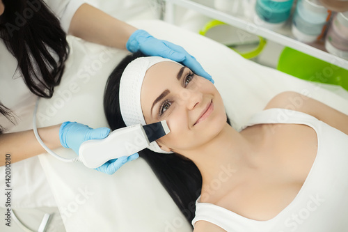 Woman receiving electric facial peeling at european beauty salon.