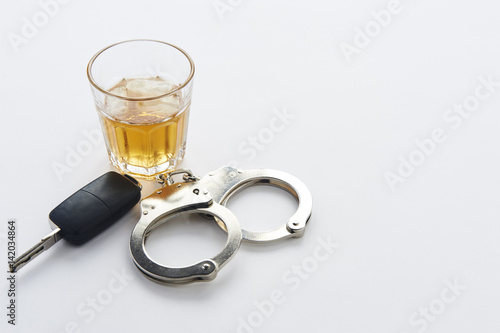 Obraz na plátně Handcuffs, keys and glass of alcohol on ice with copy space
