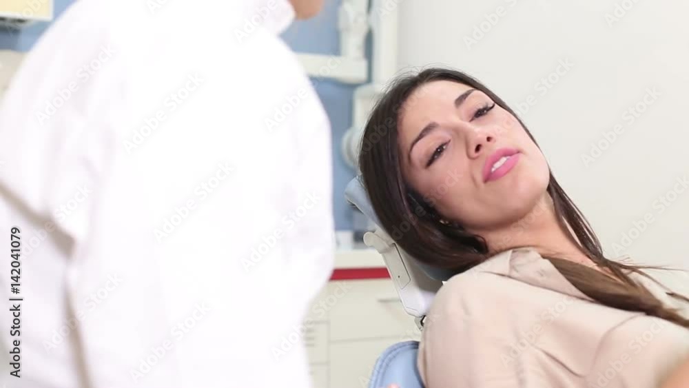 Close up of beautiful female patient talking with dentist and showing aching tooth Close up of beautiful female patient talking with dentist and showing aching tooth