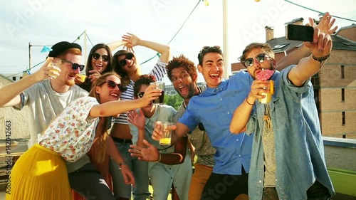 Group of crazy young friends taking selfie on the rooftop terrace, graded