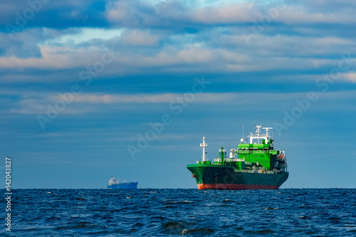 Green cargo ship moored in still Baltic sea water