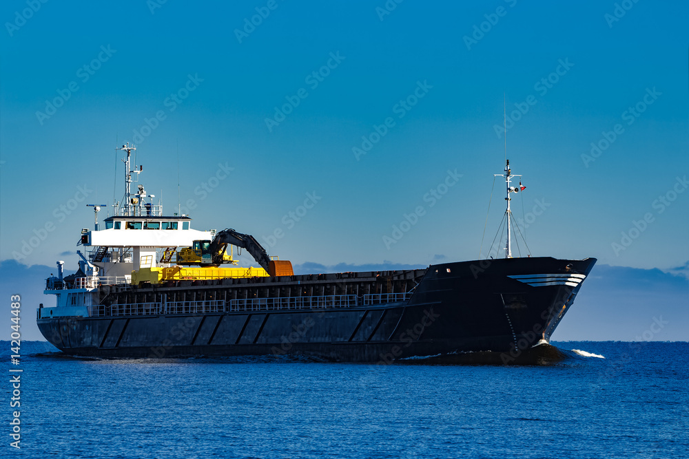 Black cargo ship with long reach excavator moving by baltic sea Black cargo ship with long reach excavator moving by baltic sea