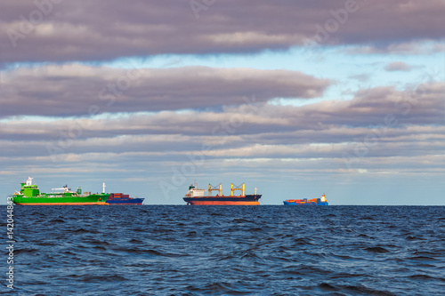 Cargo ships moored in still Baltic sea water