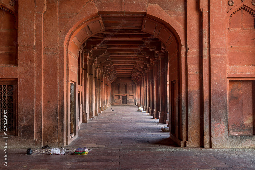 Red sandstone pillar corridor at Fatehpur Sikri Agra. Fatehpur Sikri fort and city showcases Mughal architecture in India and designated as UNESCO world heritage site.
