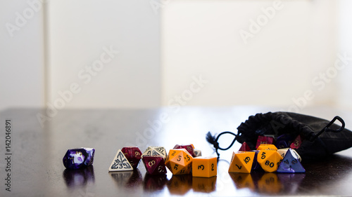 Colorful roleplaying dice scattered on a table with reflection