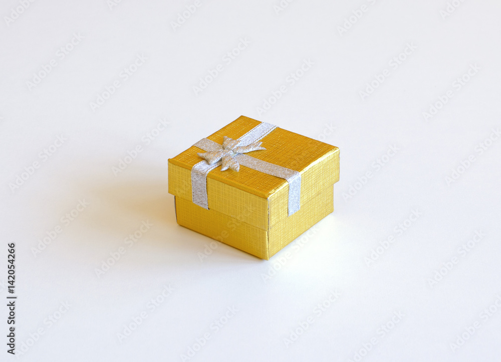 Still life with golden gift box with ribbon isolated on white background Still life with golden gift box with ribbon isolated on white background