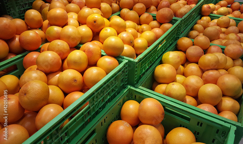 stacks of orange exotic fruits in supermarket store