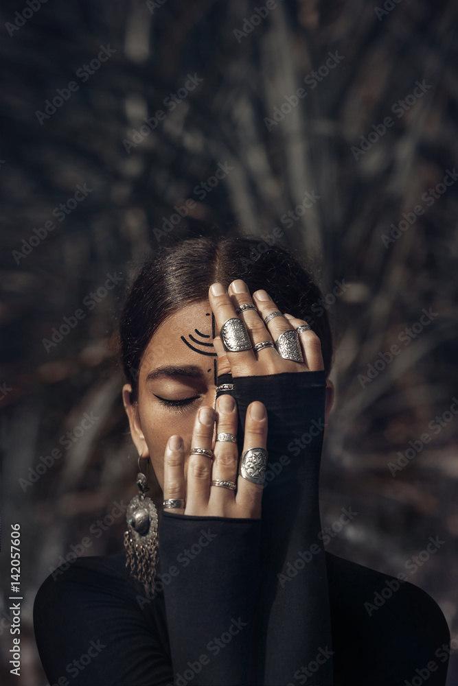 Fototapeta premium beautiful tpyng woman in black dress cover half of face with hands