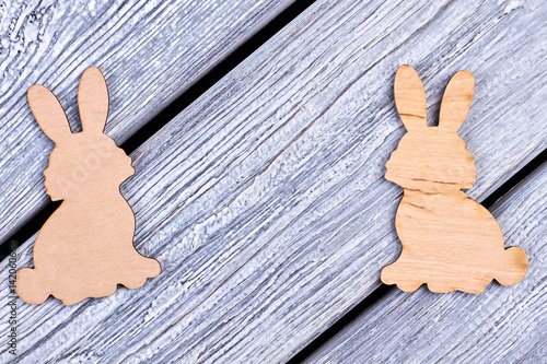 Plywood Easter rabbits. Cutout figurines of bunnies. Animalistic decorative items. photo