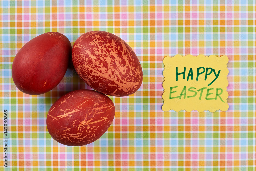 Naklejka premium Painted red eggs. Happy Easter handmade card. Topical Easter attributes.