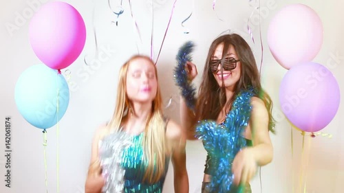 Two beautiful sexy girls dancing with props in party photo booth, graded