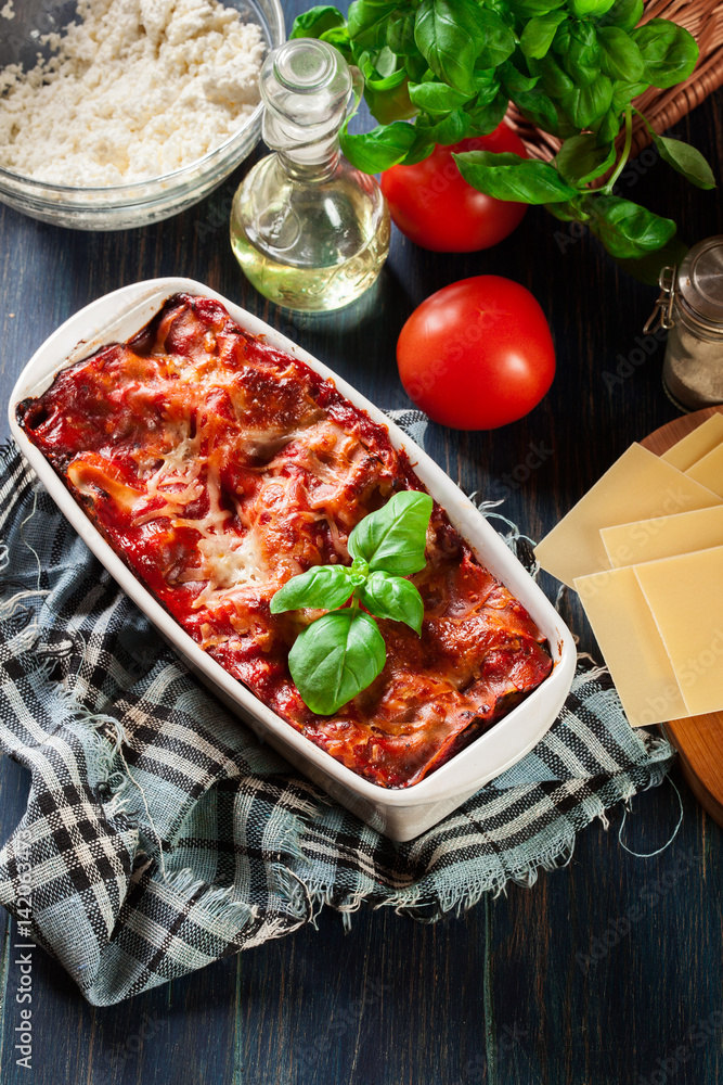 Hot tasty lasagna with spinach in ceramic casserole dish