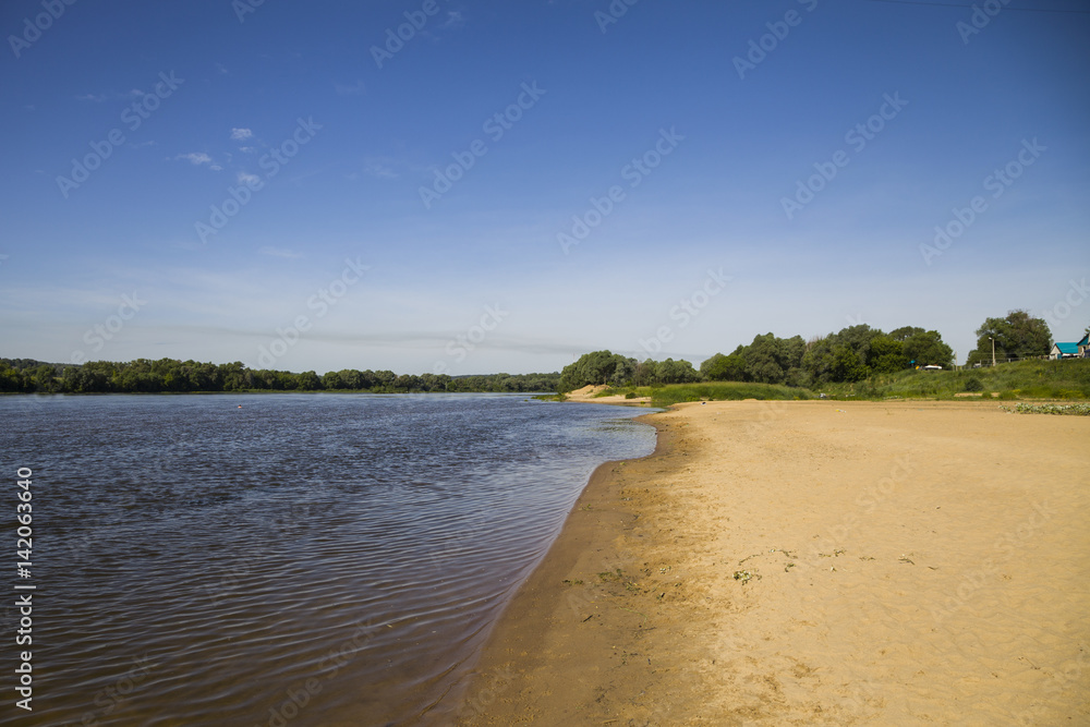 beautiful landscape with a river and a sandy beach on a summer day.