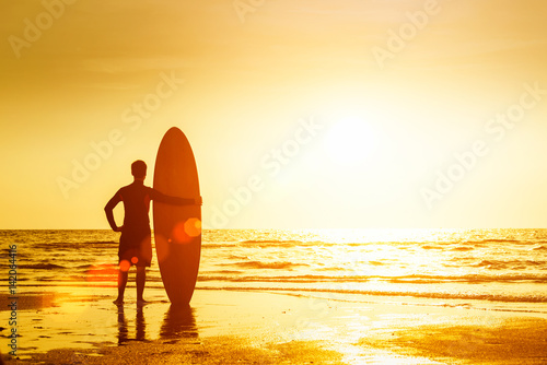 Happy surfer  standing with surfboards on the beach