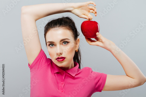 A pretty woman taking a bite out of a red apple photo