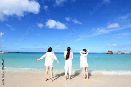 海辺で遊ぶ三人の女性 