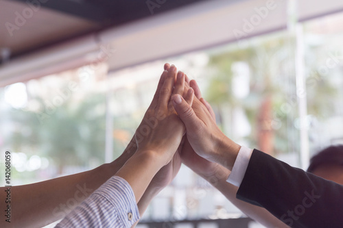 business people putting hands together to form a pyramid to show determination or teamwork spirit