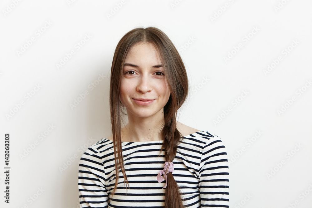 Happy excited cute student girl with messy hair braid dressed in casual striped long-sleeved t-shirt having good mood while enjoying first day of vacations at home. People, leisure and lifestyle Happy excited cute student girl with messy hair braid dressed in casual striped long-sleeved t-shirt having good mood while enjoying first day of vacations at home. People, leisure and lifestyle