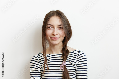 Happy excited cute student girl with messy hair braid dressed in casual striped long-sleeved t-shirt having good mood while enjoying first day of vacations at home. People, leisure and lifestyle © wayhome.studio 