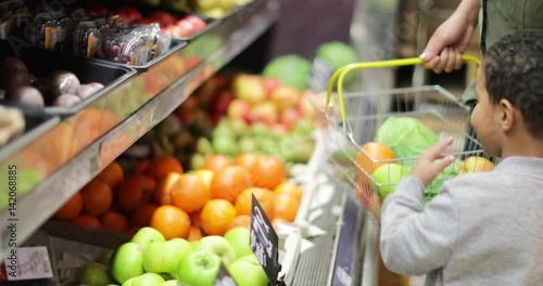Mother and son buying fruit and vegetables in grocery store
