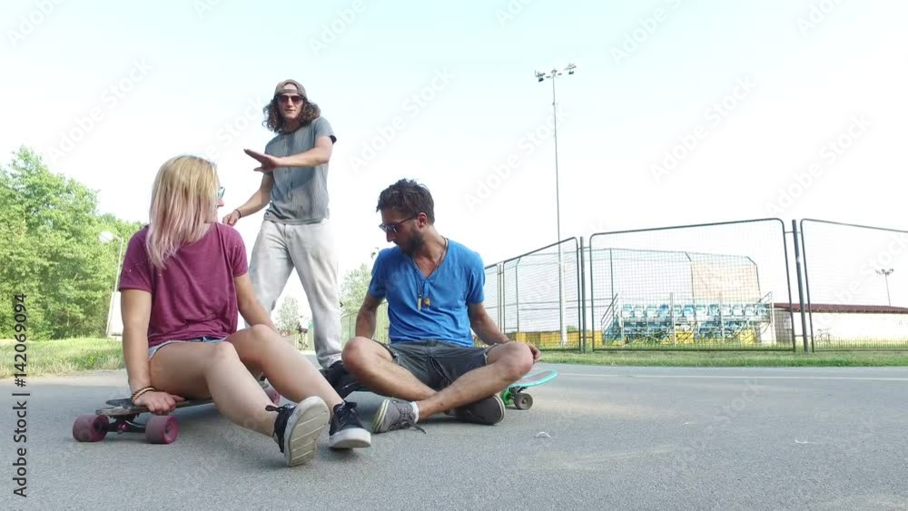 Cool young friends relaxing after skateboarding