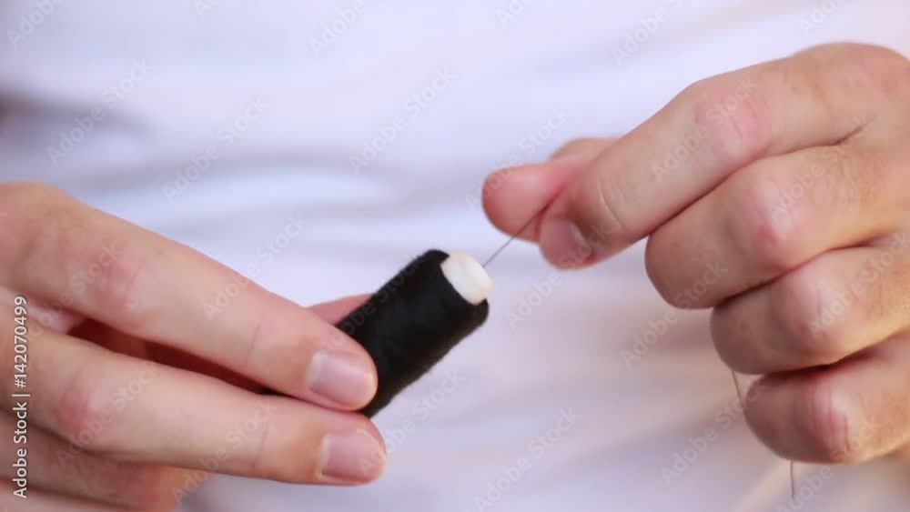 Cutting a black thread from a bobbin Cutting a black thread from a bobbin
