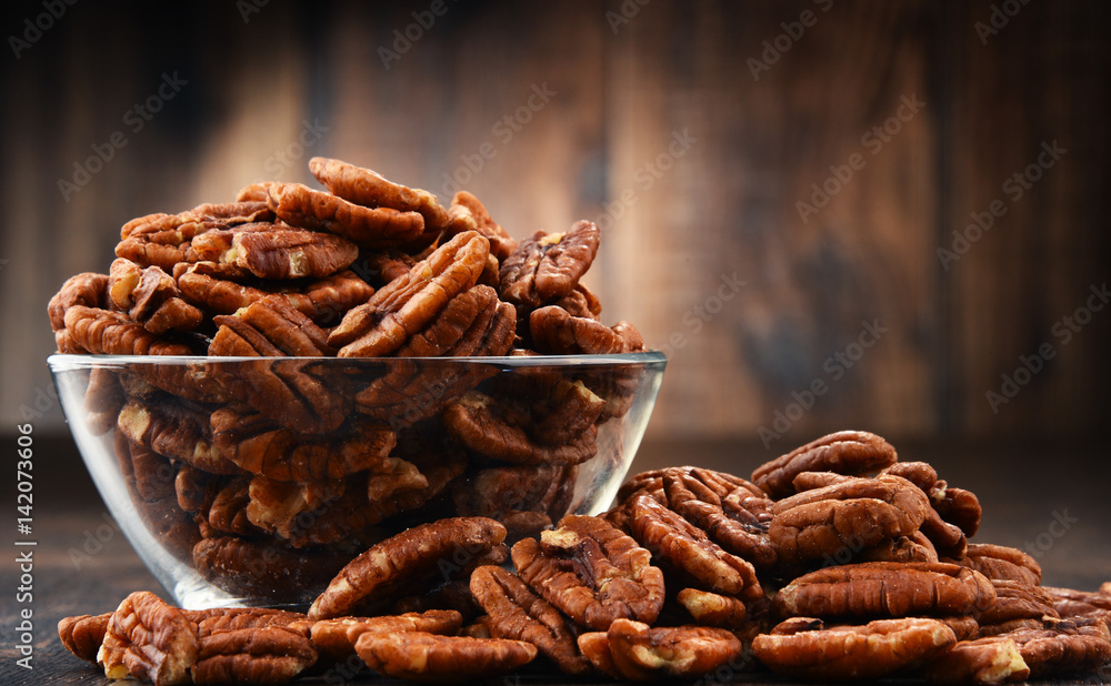 Bowl with pecan nuts on wooden table. Bowl with pecan nuts on wooden table.