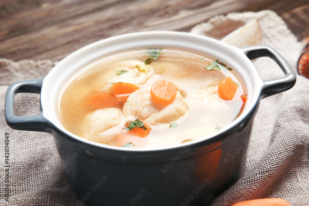 Ceramic pan with delicious chicken and dumplings on decorative napkin Ceramic pan with delicious chicken and dumplings on decorative napkin
