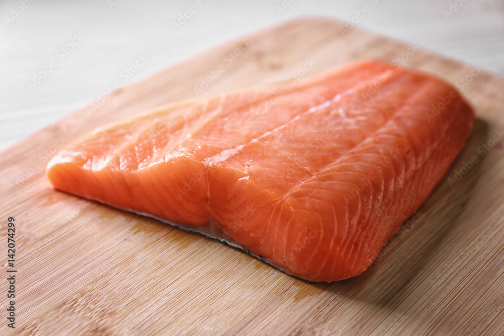 Fresh salmon fillet on wooden cutting board Fresh salmon fillet on wooden cutting board